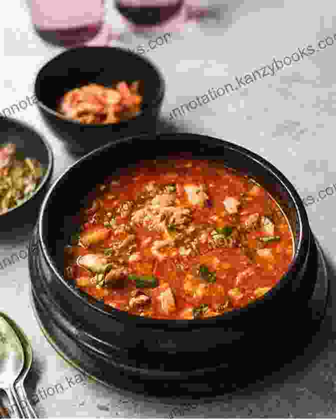 A Bowl Of Sundubu Jjigae, Featuring A Silky Smooth Broth With Soft Tofu, Seafood, And Vegetables. KOREAN FOODS IN WINTER YOU CAN NOT MISS