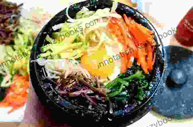 A Sizzling Hot Stone Bowl Of Dolsot Bibimbap, Filled With Rice, Vegetables, Meat, And A Fried Egg. KOREAN FOODS IN WINTER YOU CAN NOT MISS